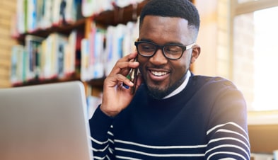 Man on cell phone with laptop