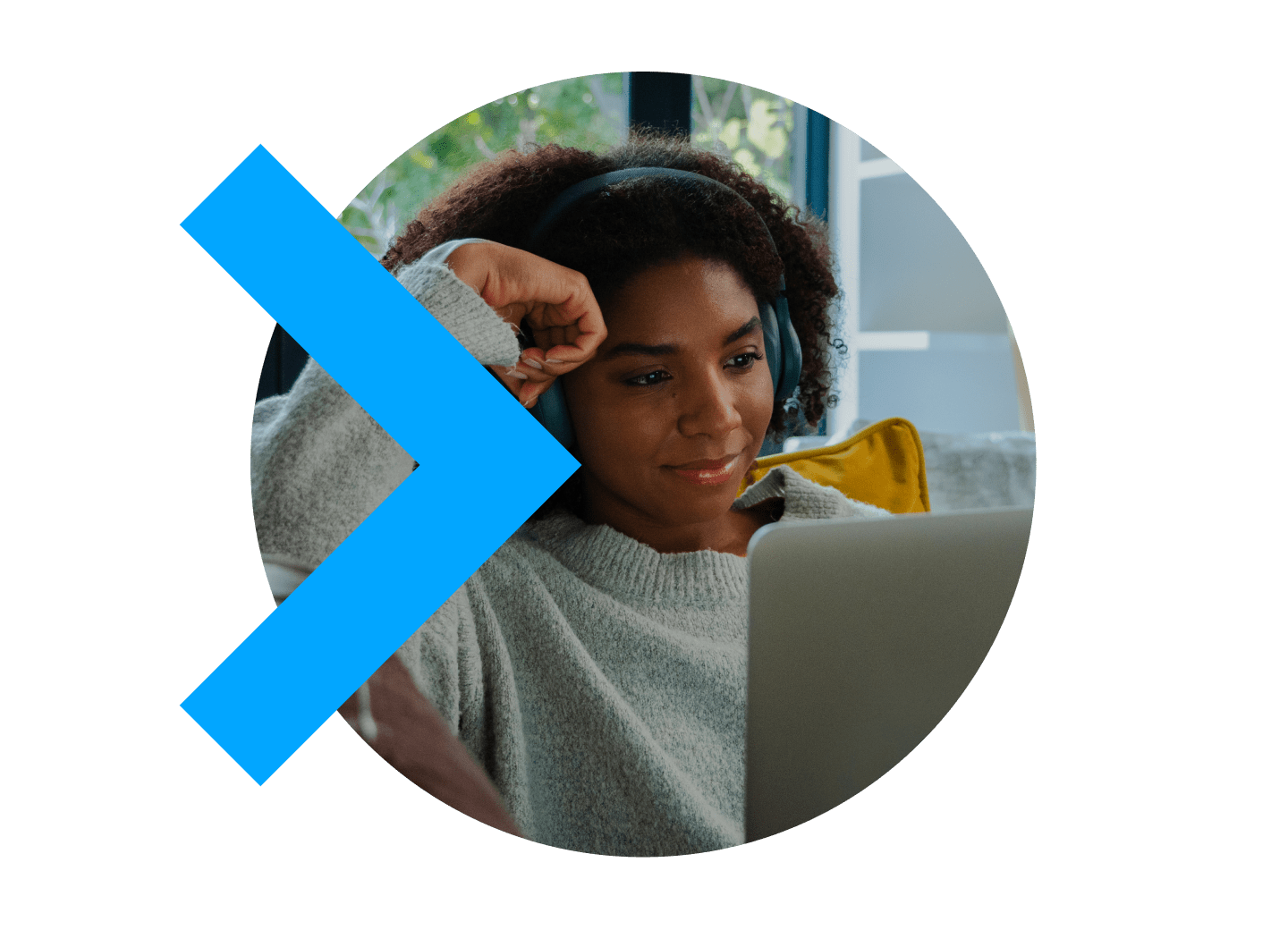 Person sitting back on couch with headphones on looking at laptop computer