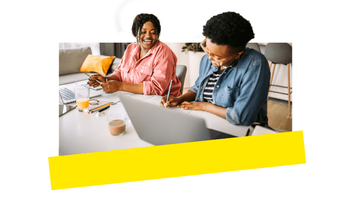 Dois colegas de trabalho rindo e se divertindo enquanto trabalham remotamente.